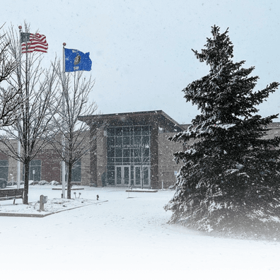 Village Hall building entrance during snowfall. 
